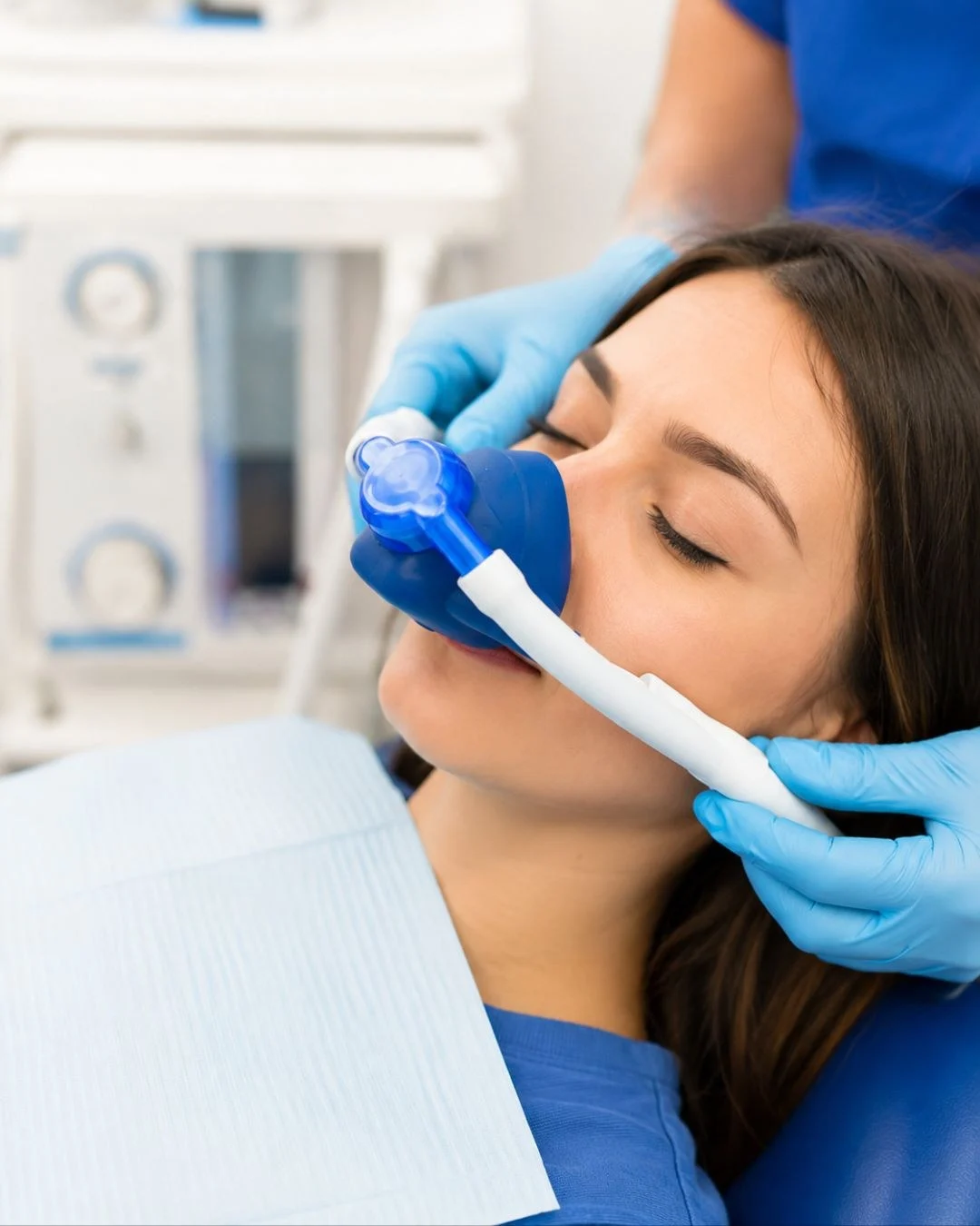 A patient relaxing in the treatment chair while a nasal hood is fitted for inhaled sedation